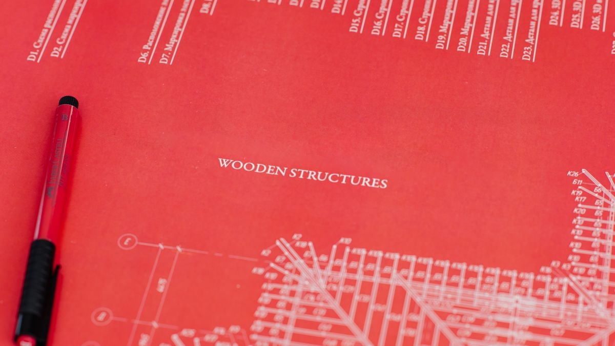 Close-up of a red architectural blueprint showcasing wooden structures.